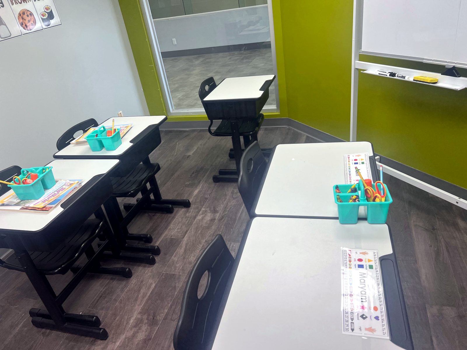 Inside the kindergarten classroom — desks set with supply caddies